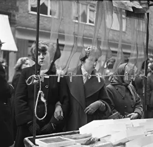 Markets Prints: Women shop for silk and nylon stocking on a market stall at an un-named street market in