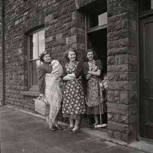 Chores Prints: Three women standing gossiping on the street outside terraced housing in Cardiff, Wales