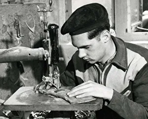 A worker concentarting at his table at a Horn making factory April 1953