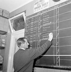 Writing Prints: A worker at George Crabbs betting shop in London writing the odds on the chalk board