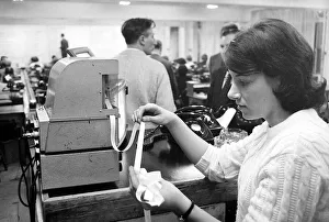 00170 Prints: A worker at Ladbrokes betting shop watching the tape machine December 1967
