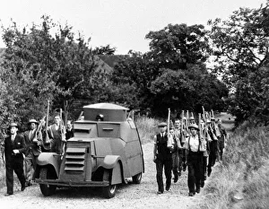 00169 Prints: Workers at a Jam Factory march besides their own armoured car during a lunch break
