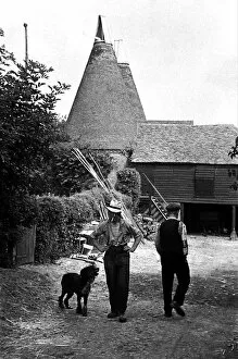 Images Dated 15th September 2015: Two workers pass each other on a farm, circa 1938