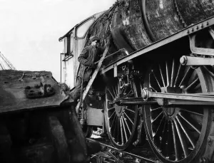 A workman cutting up an old engine at a breakers yard at North Blyth on 5th January 1965