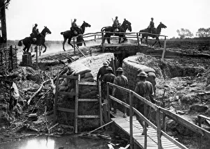 Cavalry Prints: World War One Cavalry crossing a bridge thrown across a trench with troops going