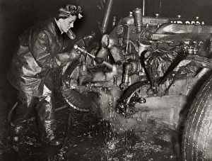 Repairing Prints: World War Two. Mrs M Bryan dressed in protective clothing cleaning dirt