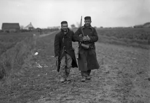 Wounded Belgian soldier helping another from the firing line during the Battle of