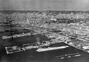 Wartime Prints: Wrecked and capsized enemy merchant vessels line the quays in the harbour at Naples
