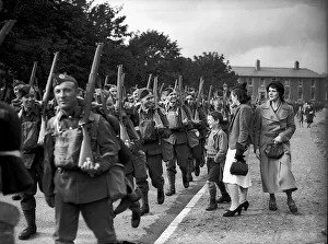 WW2 British Soldiers in England march along the road past family