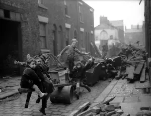 WW2 Children playing in bomb debris Debris from a night of bombing provides fuel