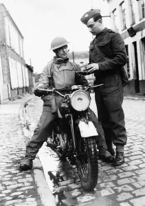 Motorbikes Prints: WW2 A dispatch rider from the Hampshire Regiment receives a message from headquarters