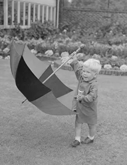 00118 Prints: Two year old Angus Cameron seen here with umbrella and his ice cream cone