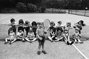 00585 Prints: Three year old Daniel Jarmin holds a tennis racket as he poses with other friends in his