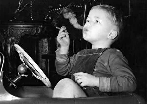 Images Dated 4th March 2008: Three year old David Fellows, puffs away happily in his pedal-car, on a man-sized cigar