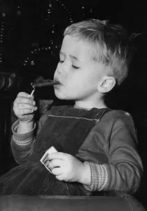 Three year old David Fellows, puffs away happily in his pedal car. 22nd December 1959