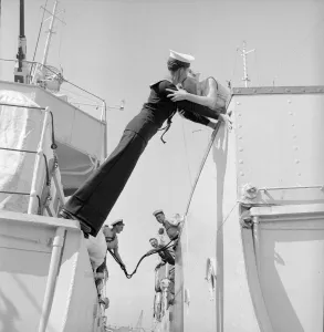 00116 Prints: Twenty year old Engineer Mechanic Alan Purton of the Royal Navy stretches across the gap