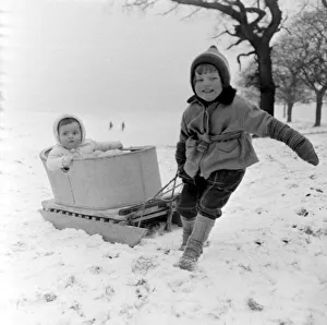 Sledging Prints: Three year old girl Linda Torkington pulls along her 10 month old baby sister Susan in a