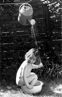 Bowl Prints: Three year old Tom Bardy is enjoying an improvised shower bath in the back garden of his