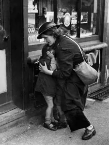 Protective Prints: Twenty four year old warden Mrs Mary Couchman crouches down to protect her young son