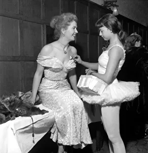 Young ballet dancer Zany Roxo pins a tiny posy of flowers on the Miss Valentina