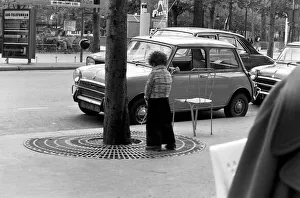 Toilet Prints: Young boy urinates outside a cafe on the Champs Elysees in Paris, France