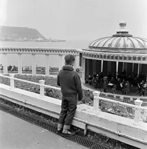 Holiday Prints: A young boy watching a band playing in the bandstand at Scarborough, North Yorkshire