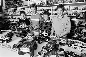 01099 Prints: Young boys playing with toy remote control cars in Hamley s, London