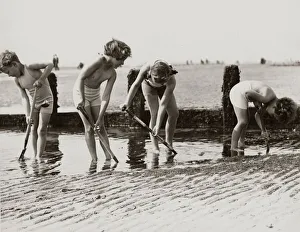 Core36 Prints: Young children looking for crabs and other beach life hiding in the sands on the beach