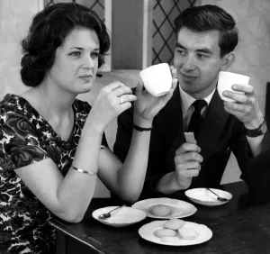 Core23 Prints: Young couple enjoying cups of tea and biscuits whilst flirting with each other
