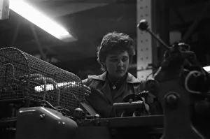 Production Line Prints: A young female employee checks that the machine has correctly filled