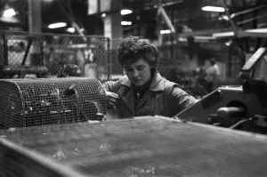 00842 Prints: A young female employee checks that the machine has correctly filled