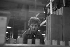 00842 Prints: A young female employee checks that the machine has correctly filled