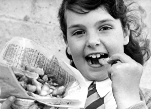 Chips Prints: A young girl enjoying fish and chips the old fashioned way from a newspaper in 1977