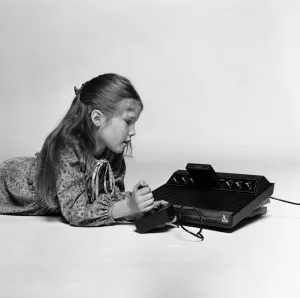 Games Prints: A young girl playing on the Atari 2600, a home video game console by Atari. December 1980