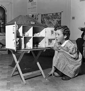 00011 Prints: Young girl playing with dolls house. October 1952 C4969