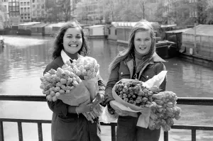 00068 Prints: Two young girls of Amsterdam holding bunches of tulips during the season May 1975