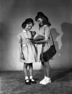 Two young girls model in their school uniforms for a Daily Herald feature titled