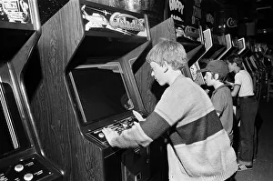 01262 Prints: Young holidaymakers play the video machines at the James Corrigan seafront amusement