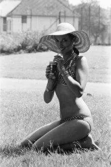 Straw Prints: Young lady cools down with a refreshment as she enjoys the summer heatwave, Teesside