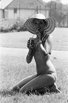 Young lady cools down with a refreshment as she enjoys the summer heatwave, Teesside