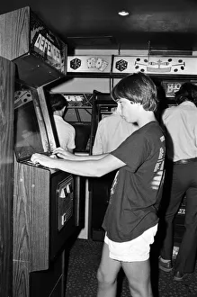Young people playing video games in an amusement arcade in London. 13th July 1983