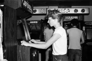 Young people playing video games in an amusement arcade in London. 13th July 1983