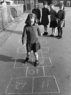 Girl Collection: Young Pgirl playing a game oh hopscotch with her friends in the school playground