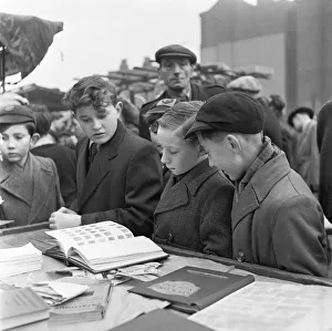 Tower Hamlets Prints: Young stamp collector looking to add to his collection at the flea market in Club Row