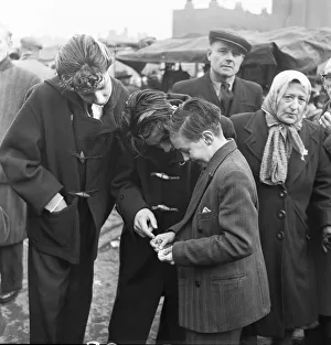 Tower Hamlets Prints: A young stamp collector shows of his latest purchases to his collection to his friends