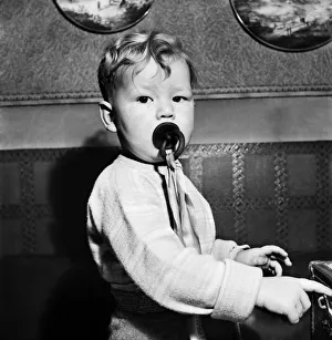00026 Prints: Young toddler boy sucking on a dummy December 1952 C6391-006