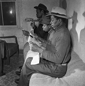Young West Indian men in Brixton looking through the small ads in the local newspapers