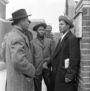 01423 Prints: Young West Indian men standing outside the Brixton Labour Exchange looking for employment