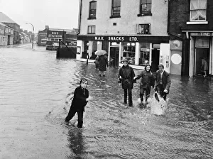 Flooding Prints: Youngsters find crossing the road difficult in a flooded Macclesfield street after heavy
