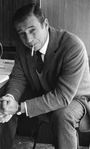 Italian Prints: Yves Montand smoking cigarette looking serious during interview - September 1965